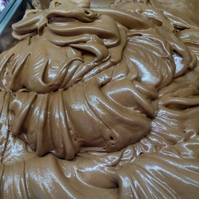 A pan of glossy chocolate-brown gelato, freshly spread