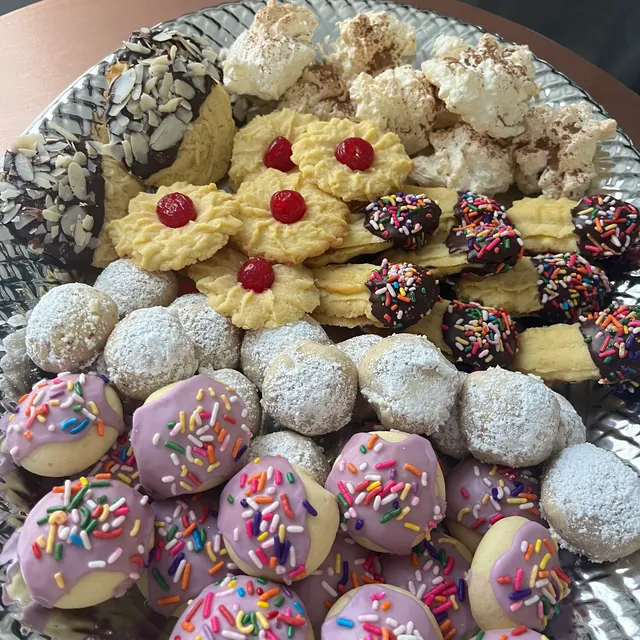 A platter of assorted cookies, some with sprinkles, some dusted with powdered sugar