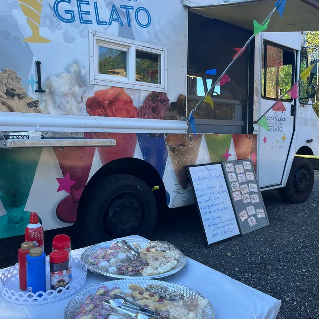 The Coppa Magica truck set up at an event, menu boards beside it