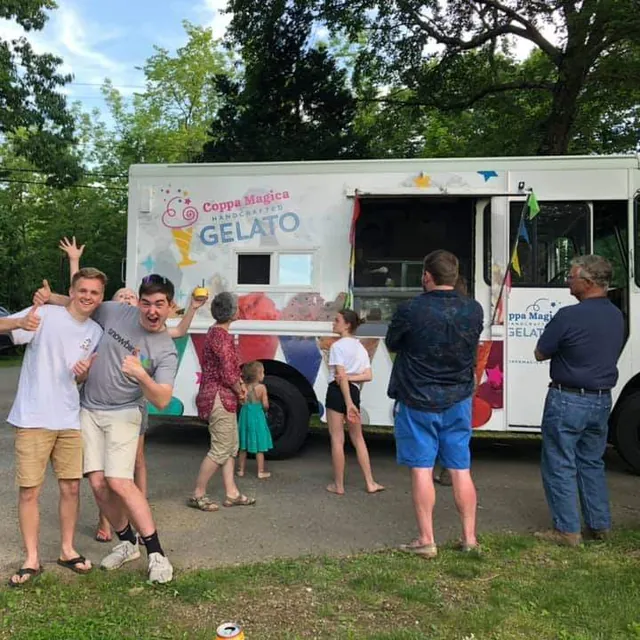 Guests gathered at the Coppa Magica truck in a parking lot under the trees