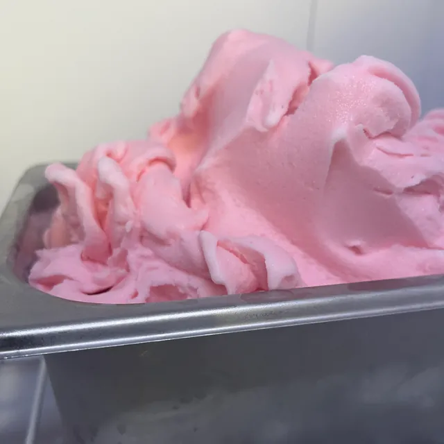 Light pink sorbetto heaped in a steel pan