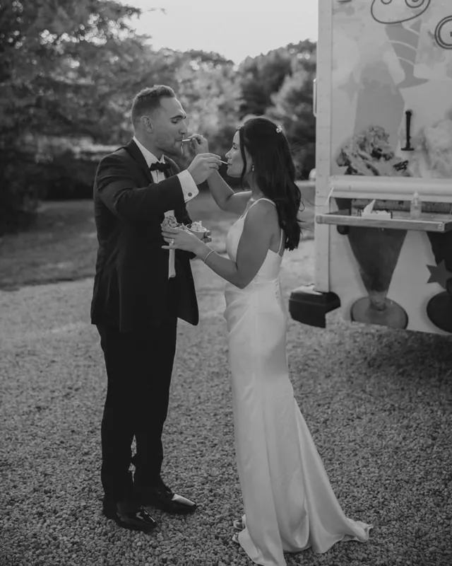 Black-and-white photo of the couple feeding each other a spoonful of gelato beside the truck