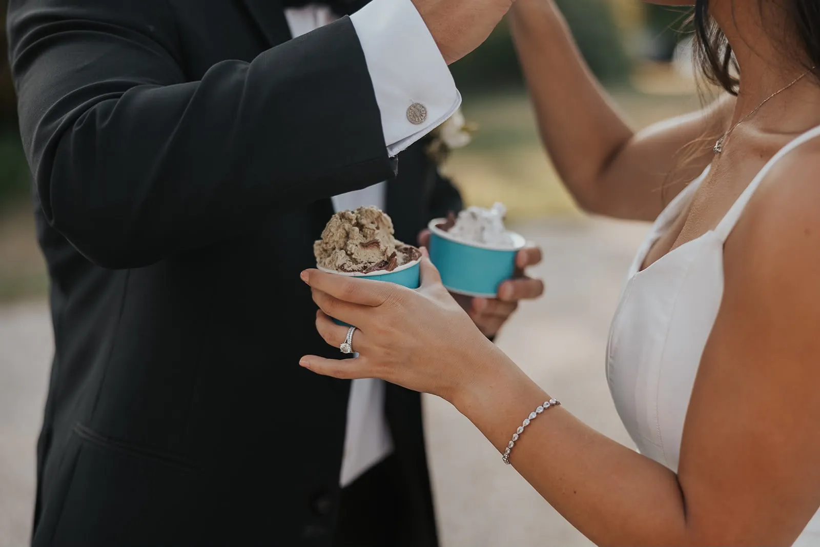 Close-up of the bride and groom holding two blue cups of gelato